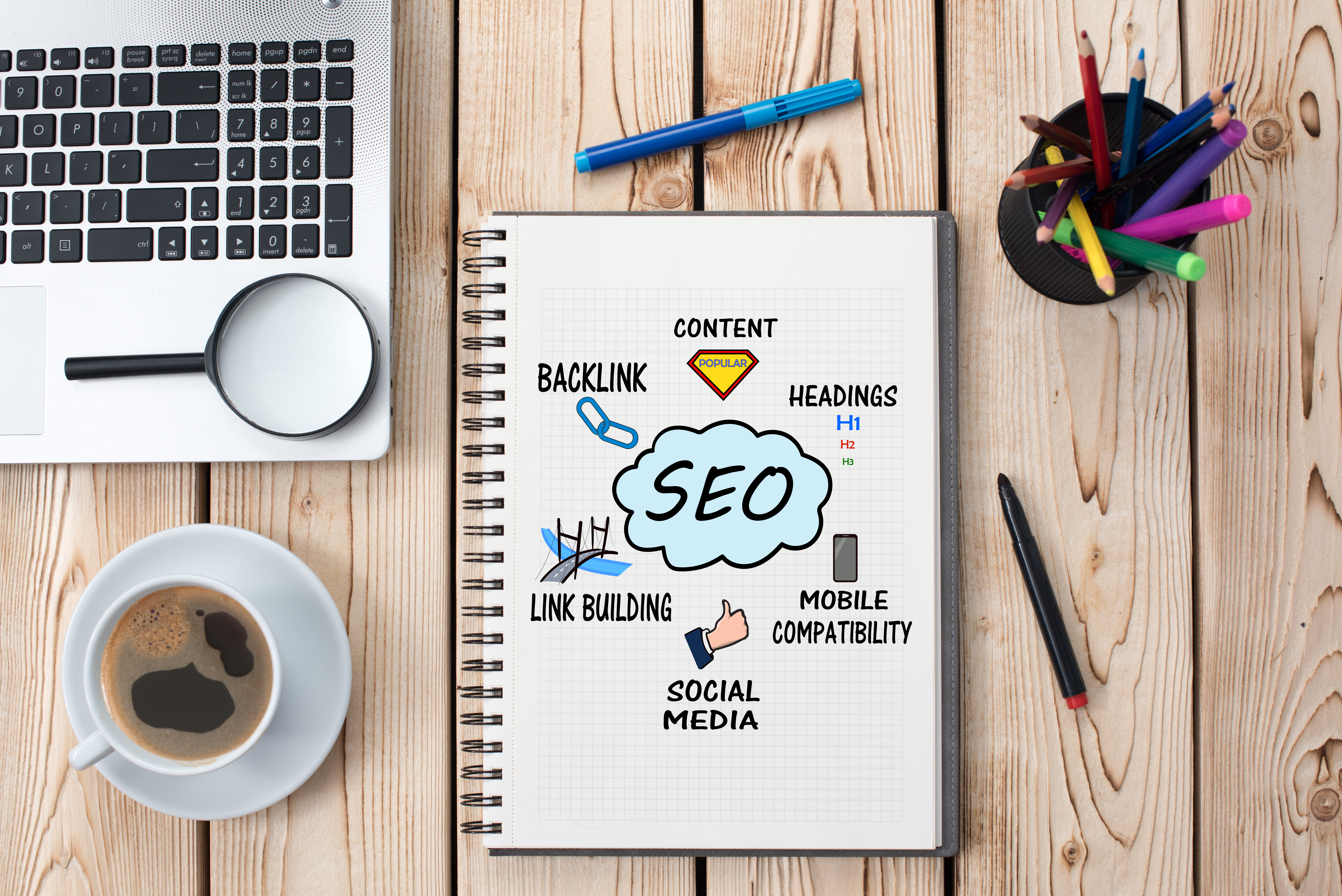Notebook with a mind map drawing of different seo optimization techniques such as content, heading, mobile compatibility, social media, link building and back link. 